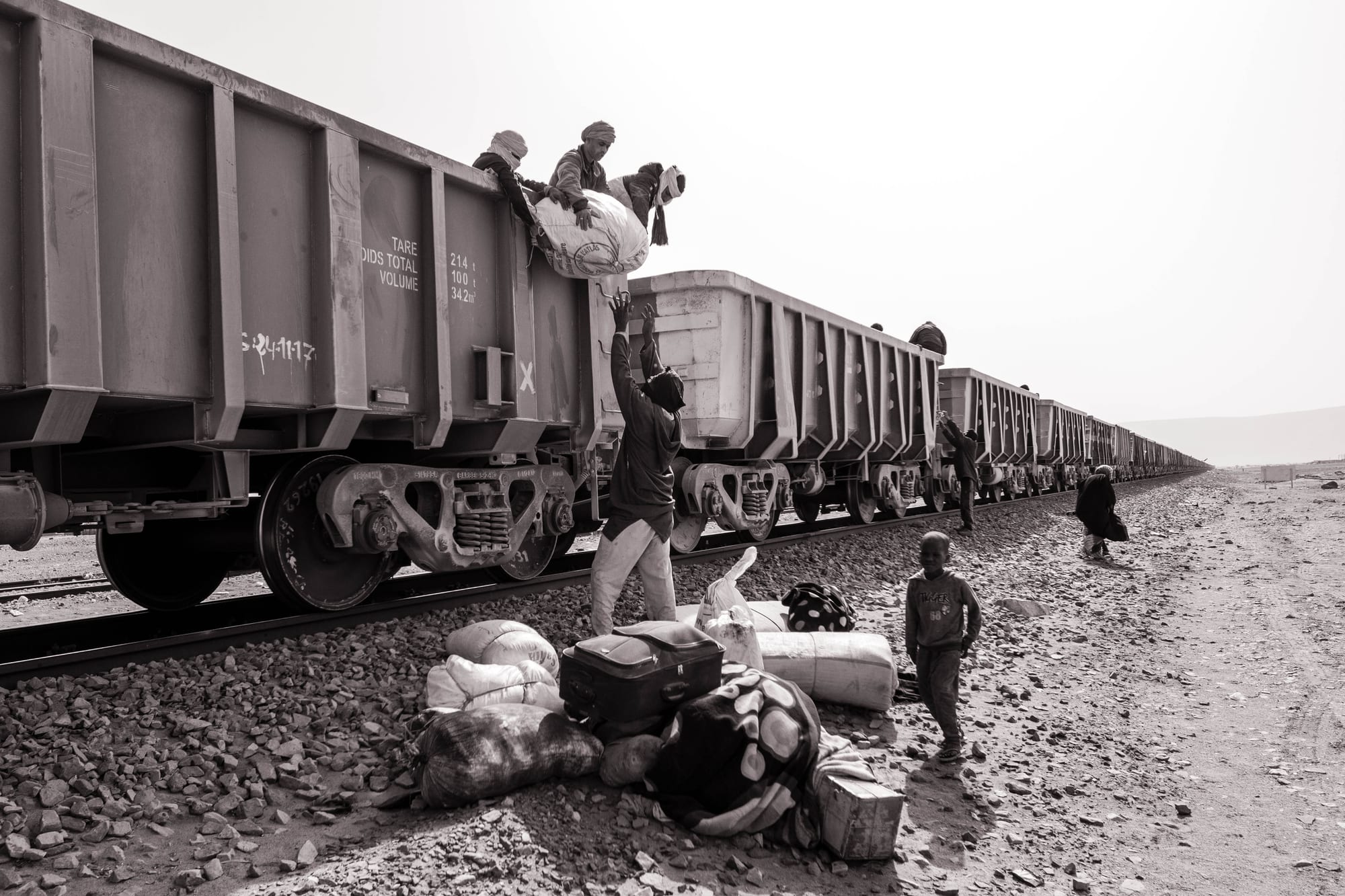 An extremely long freight train loaded with iron ore crossing flat desert