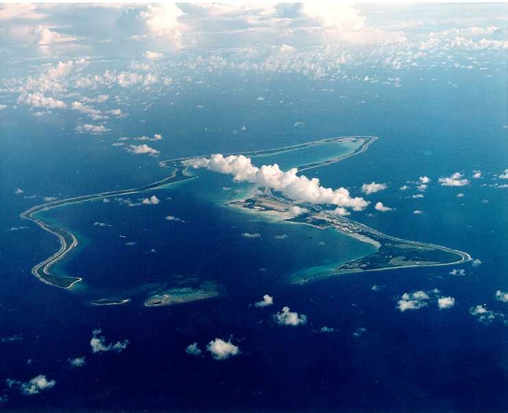 An aerial view of the narrow ring of Diego Garcia atoll with a runway and harbour