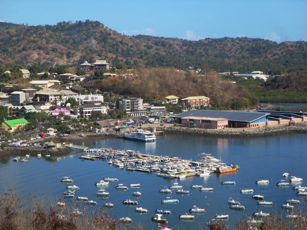 The waterfront town of Mamoudzou with market buildings, taxis and hills rising behind