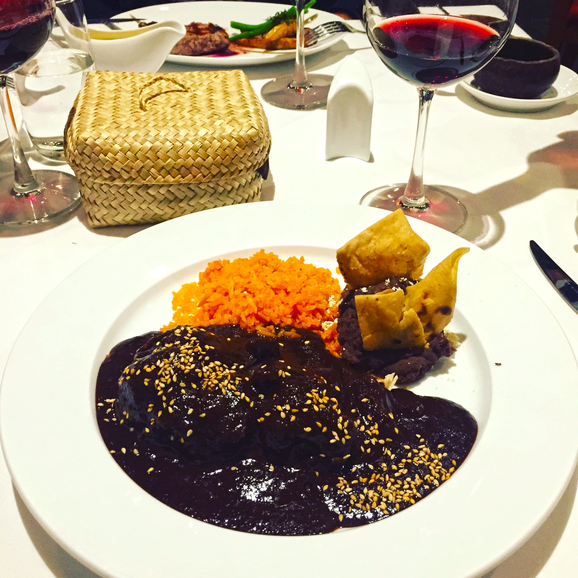 A dark, rich sauce over meat, served with rice and beans