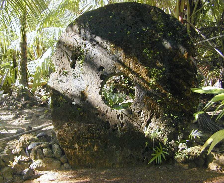Large circular stone discs with a hole in the centre, leaning against each other