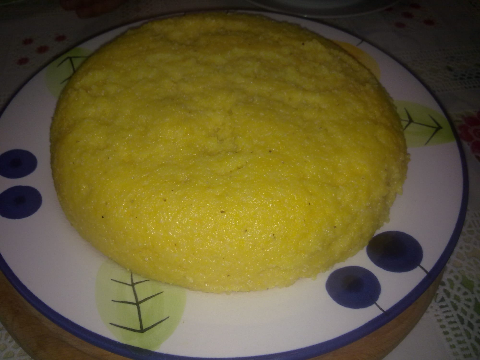 A round of firm yellow cornmeal porridge on a plate