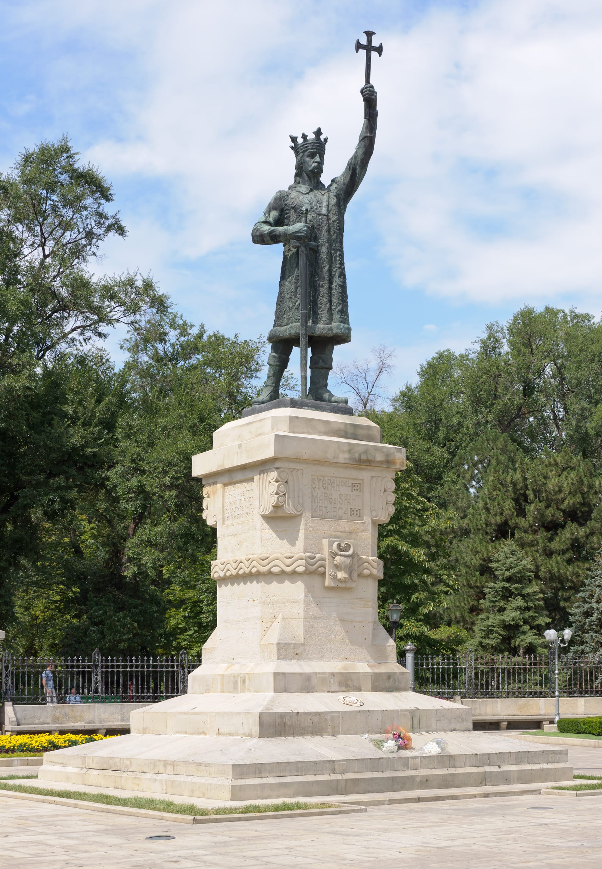 A bronze statue of Stephen the Great holding a cross and sword, on a tall pedestal in Chișinău