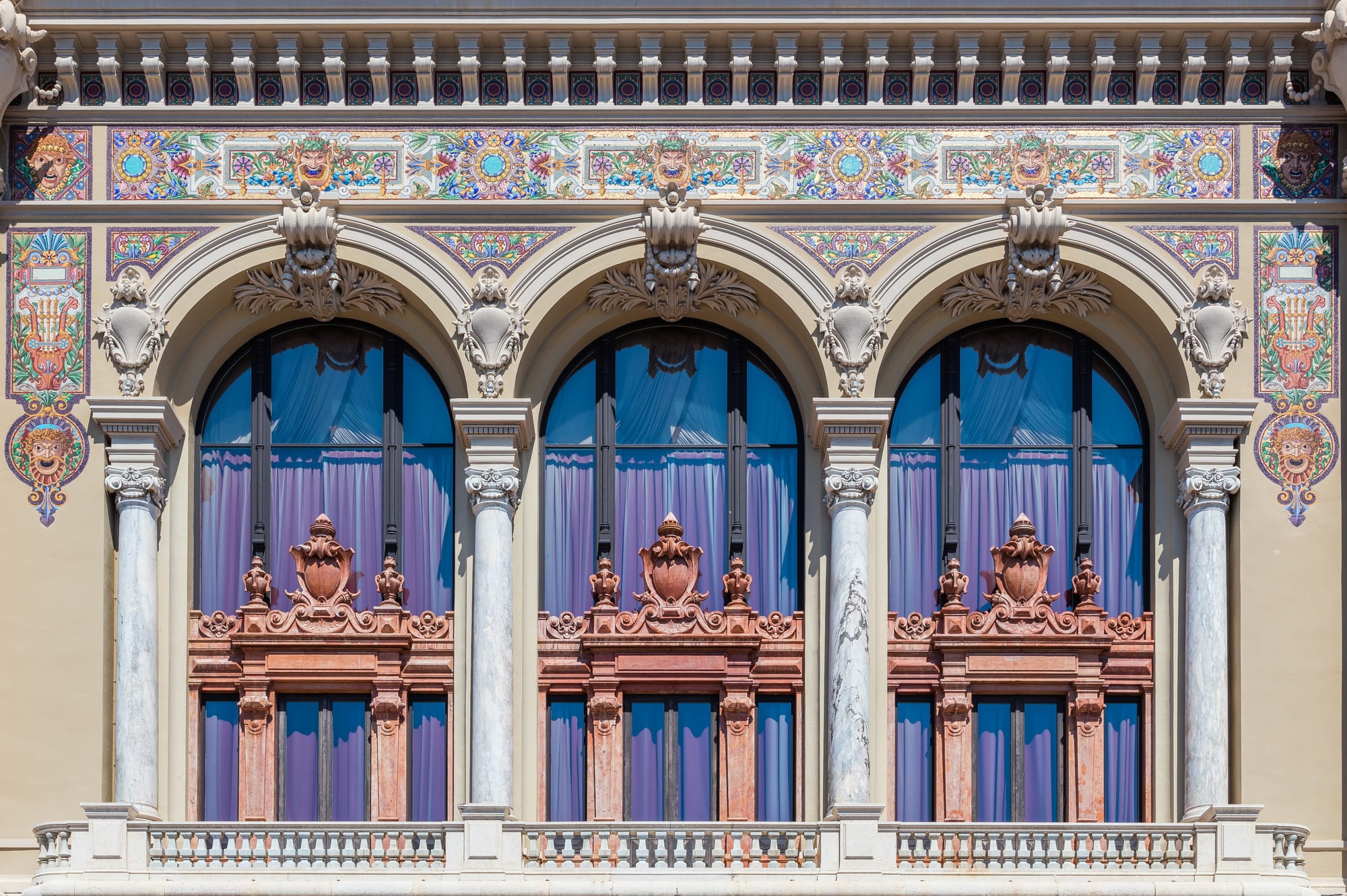 An ornate Belle Époque casino building with towers and gardens under a blue sky