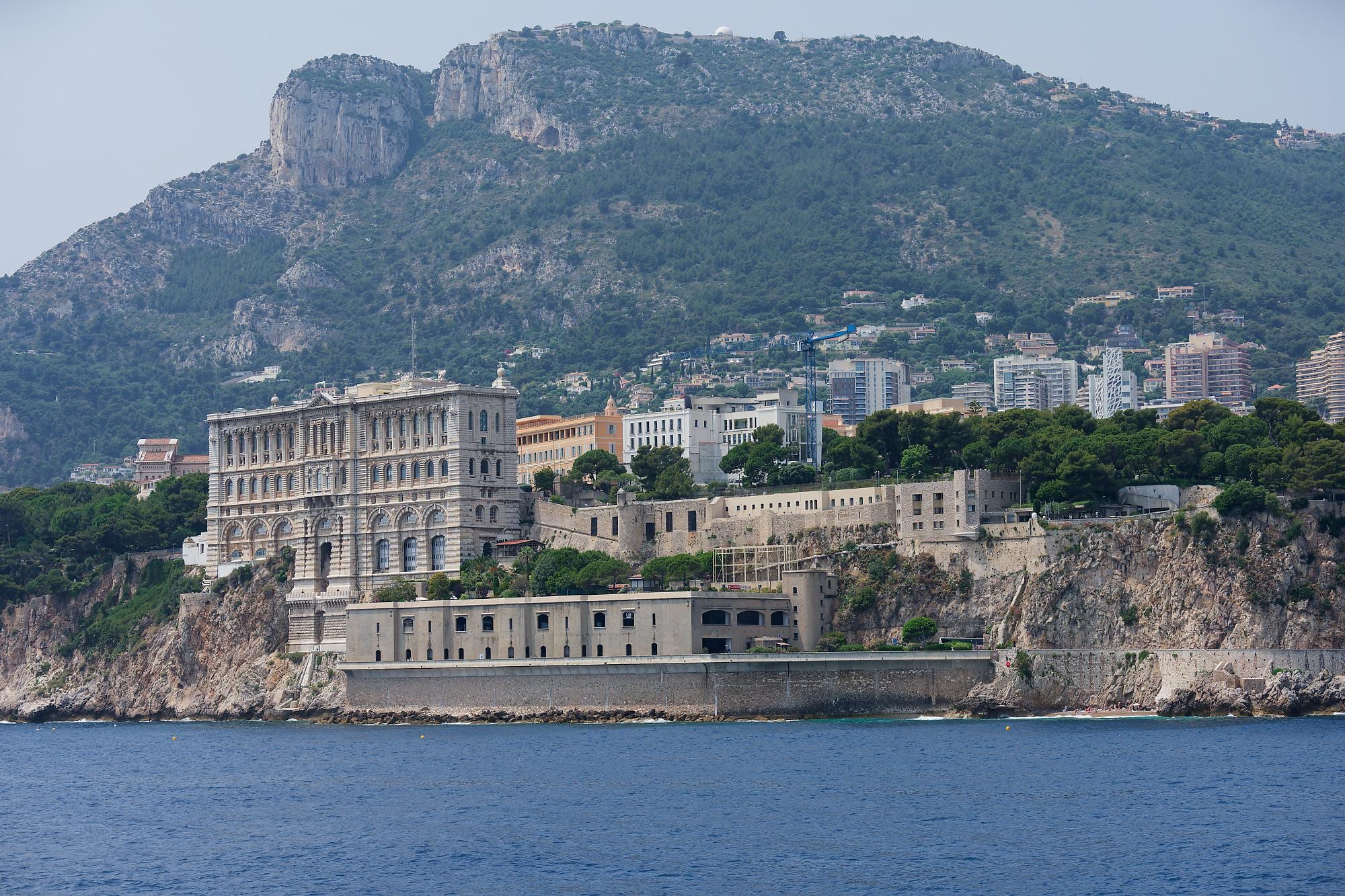 A grand stone building perched on a cliff edge above the sea