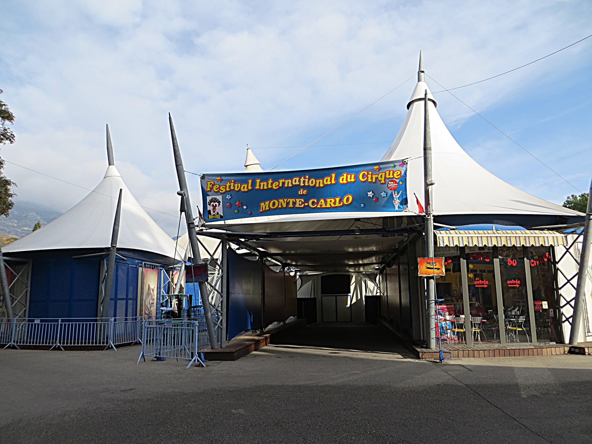 A white and blue circus big top with pointed peaks and a large blue banner reading Festival International du Cirque de Monte-Carlo over the entrance