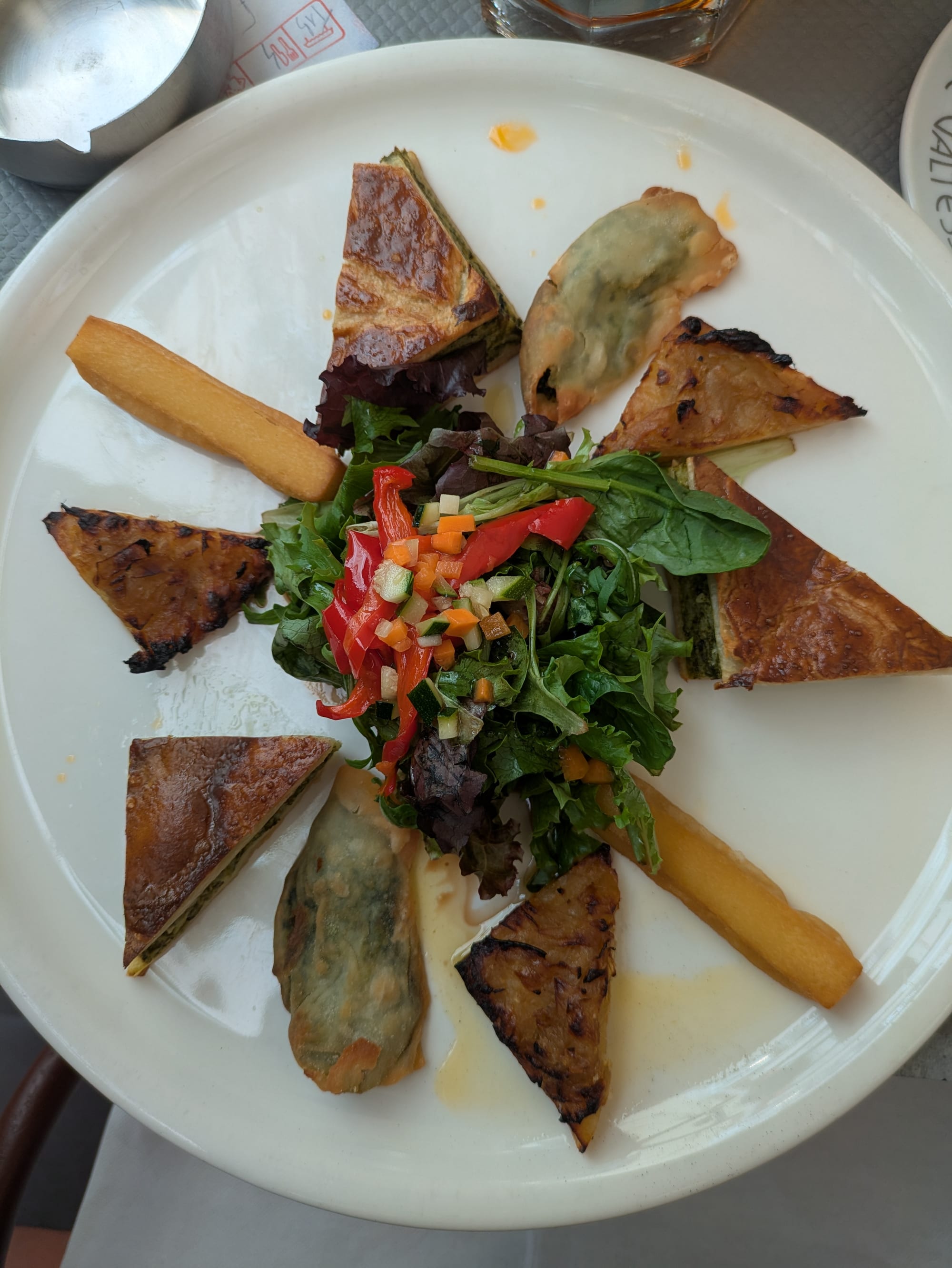 A platter of small pastries, fritters and vegetable dishes