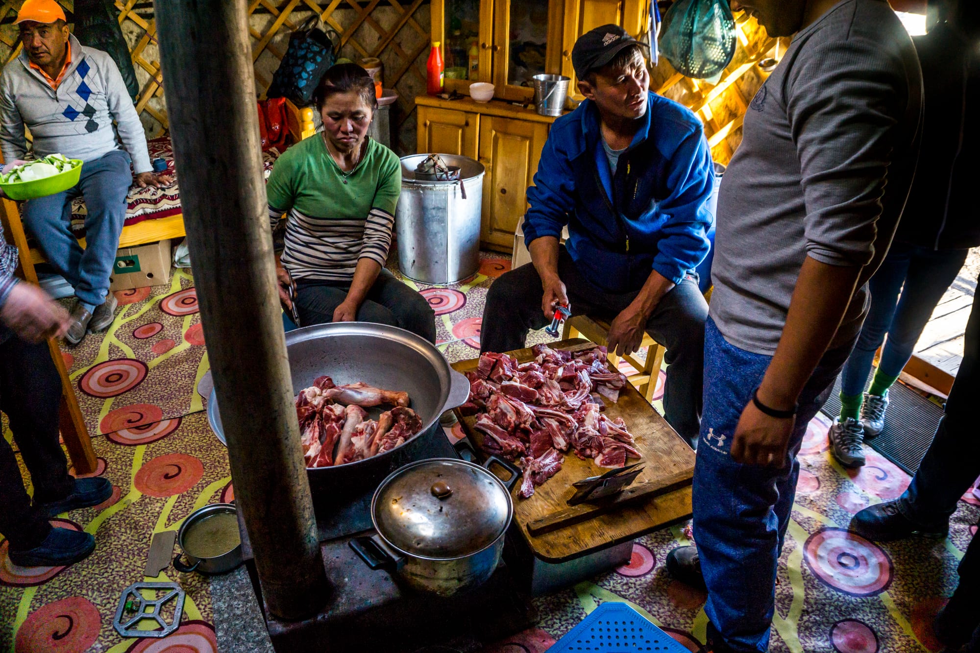 A large pot with meat and hot stones being prepared inside a ger