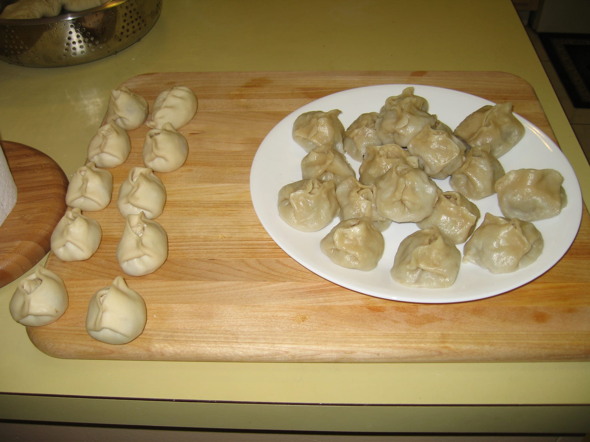 Steamed dumplings, some whole and some cut open showing meat filling