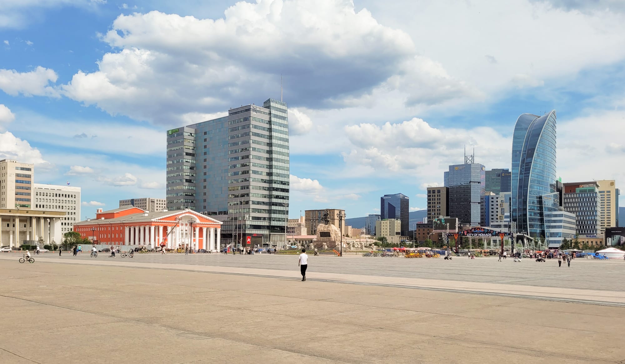 A large public square in Ulaanbaatar with government buildings and a mounted statue
