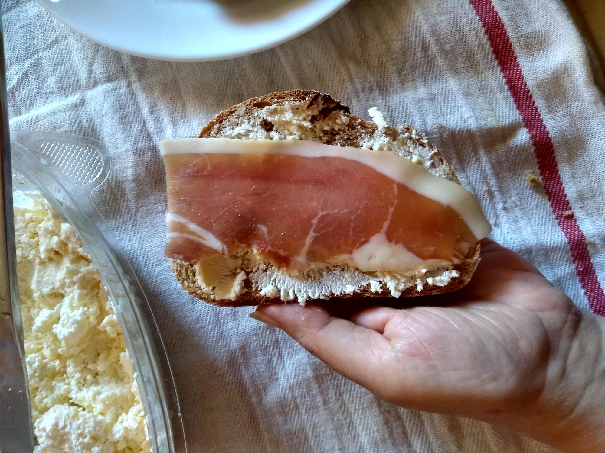 Sliced cured ham served alongside a bowl of cream cheese