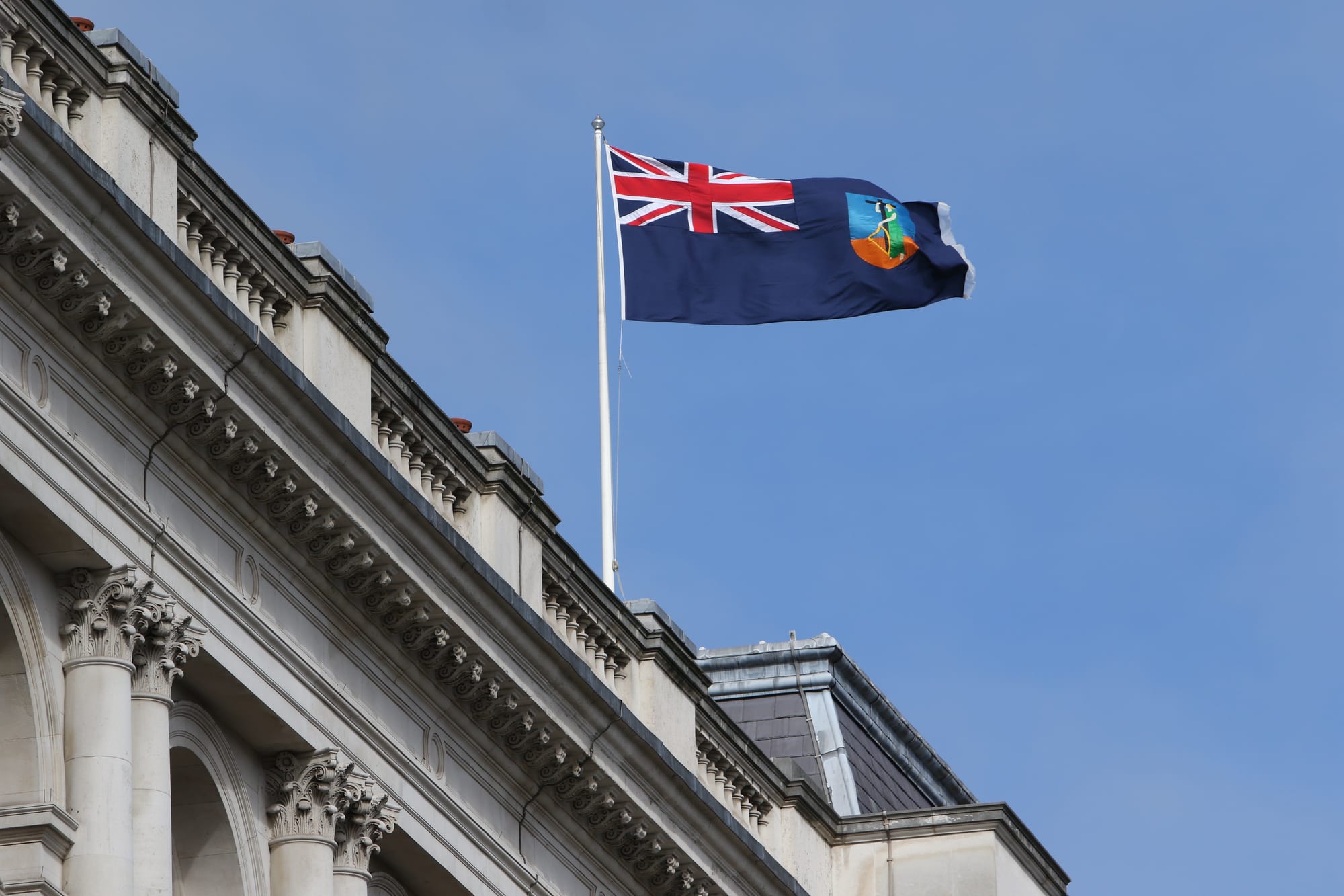 The blue Montserrat flag with the Union Jack and a shield showing a woman with a harp and cross