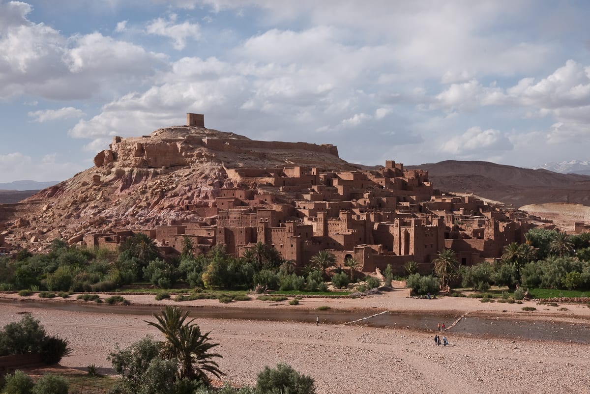 A fortified earthen village of towers and walls rising on a hillside