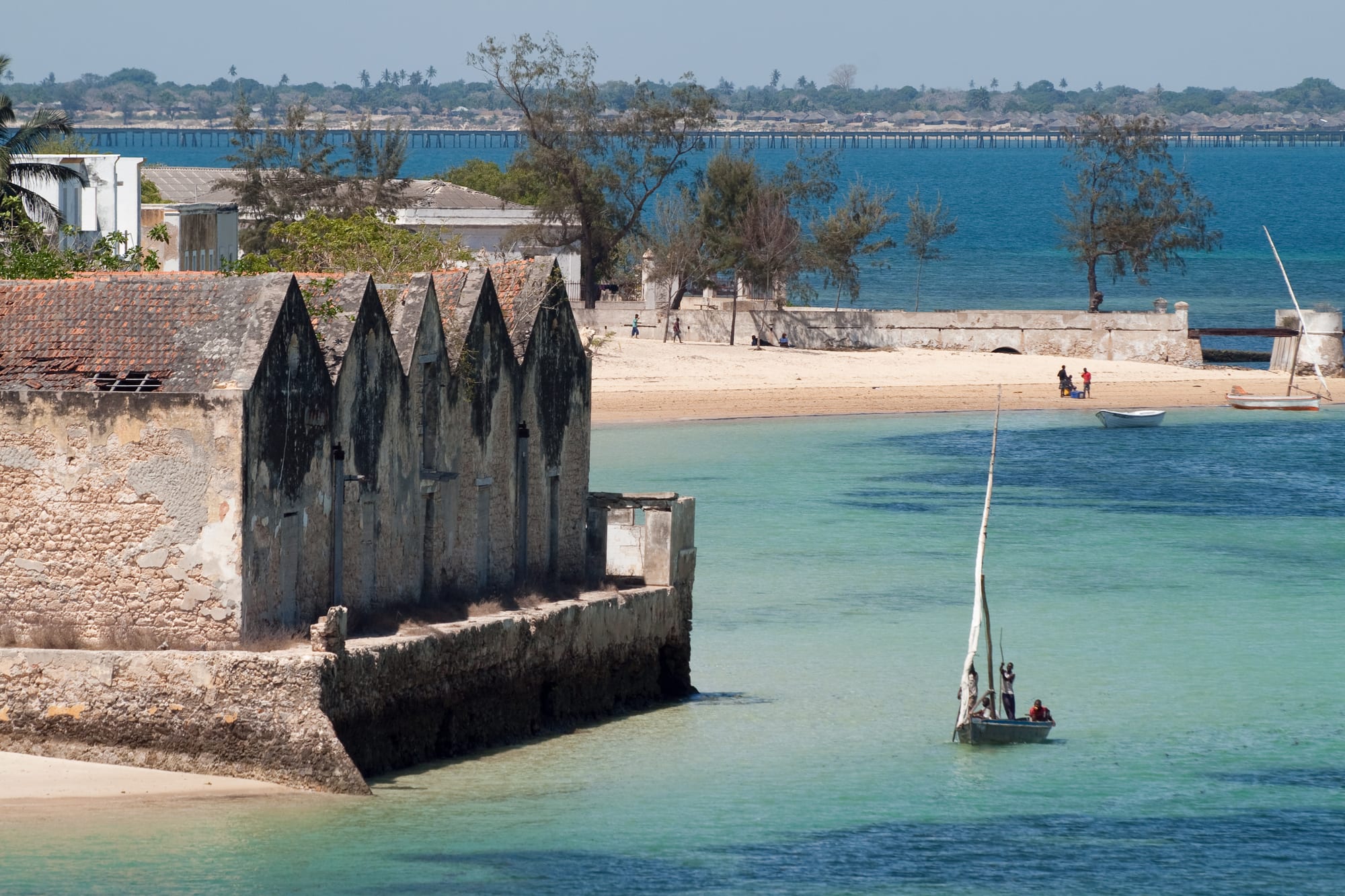 A dense low-rise coastal town of coral-stone and colonial buildings on a narrow island