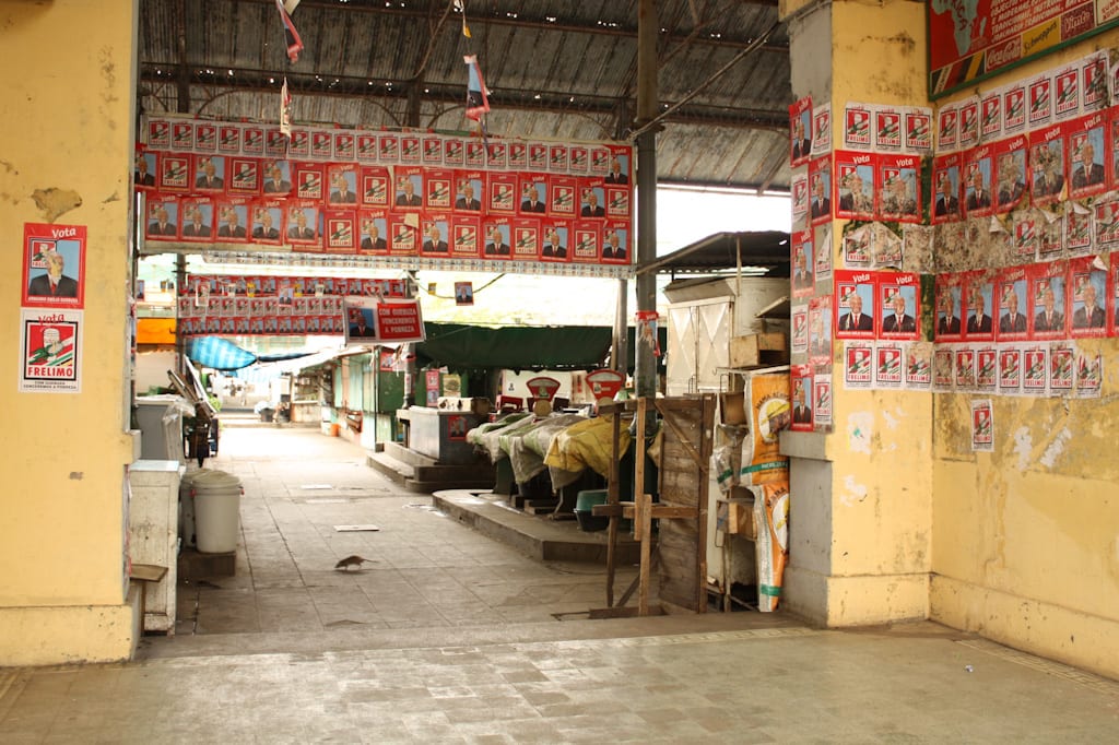 A busy indoor market hall with vendor stalls
