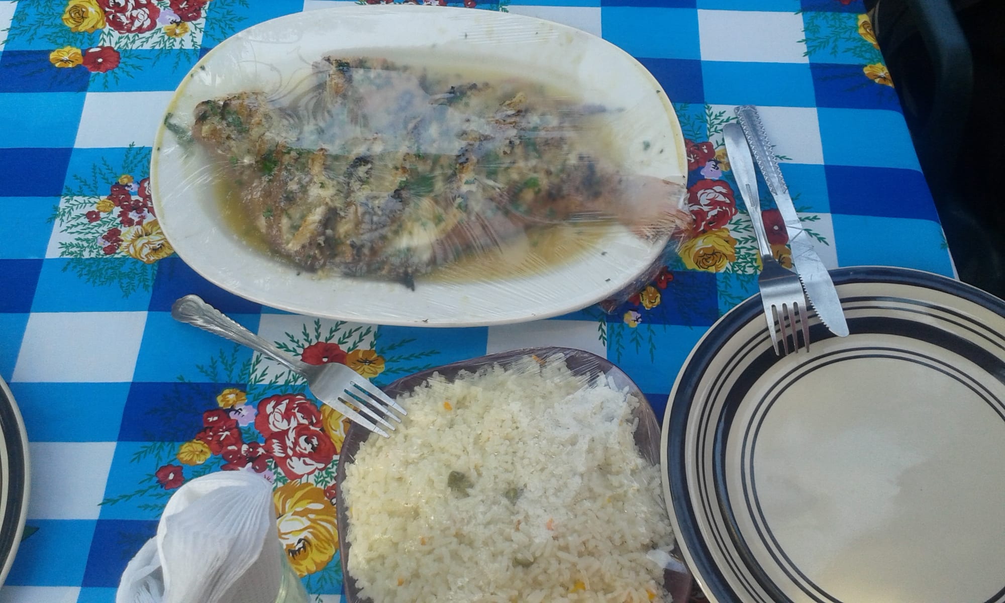 A piece of grilled red fish served with a mound of firm maize porridge