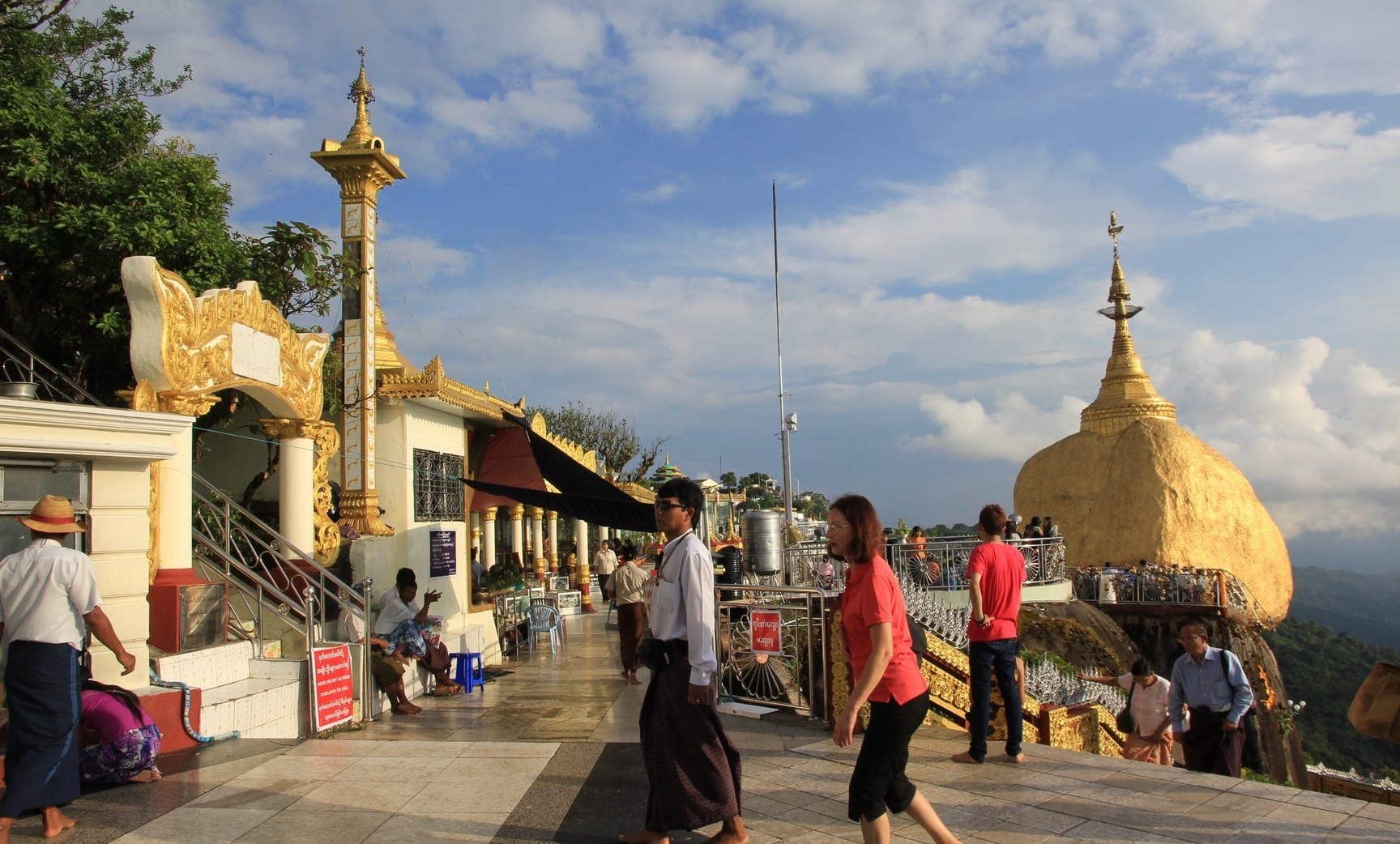 A gold-leafed boulder balanced precariously on the edge of a cliff, a small pagoda on top