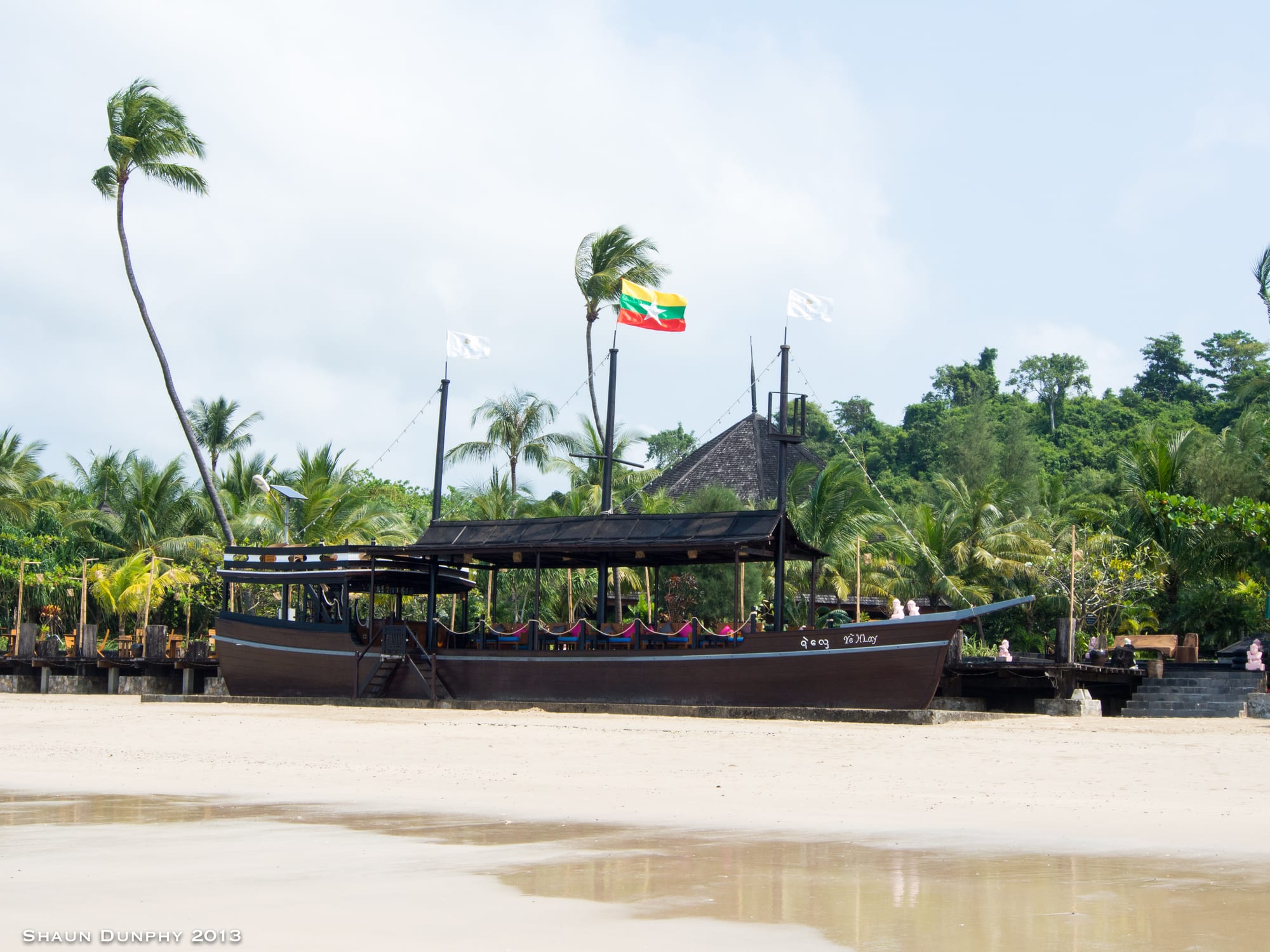 A palm-lined white sand beach with calm turquoise water