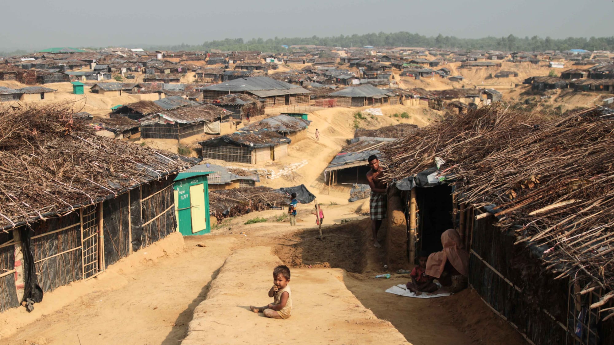A vast hillside covered in the bamboo-and-tarpaulin shelters of a Rohingya refugee camp