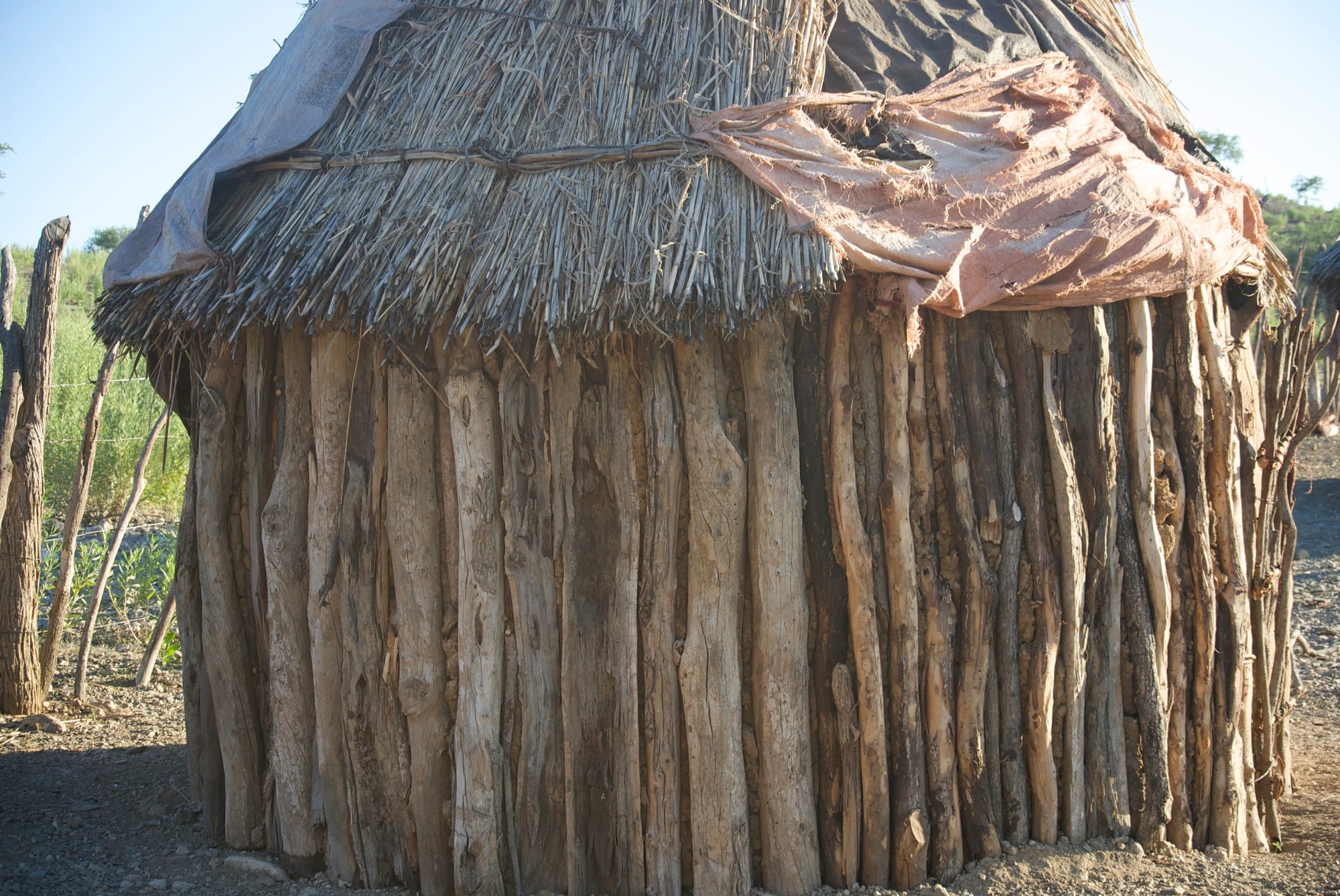 A traditional conical Himba hut built from bundled sticks and a thatched roof
