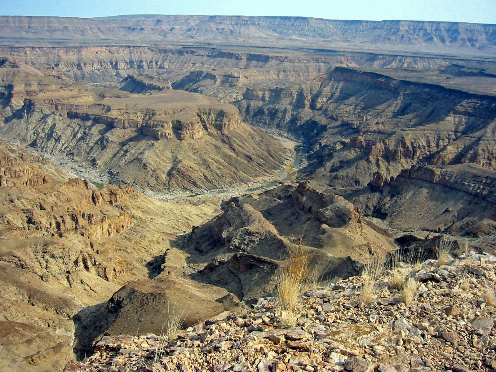 A vast, deep, layered rock canyon stretching to the horizon