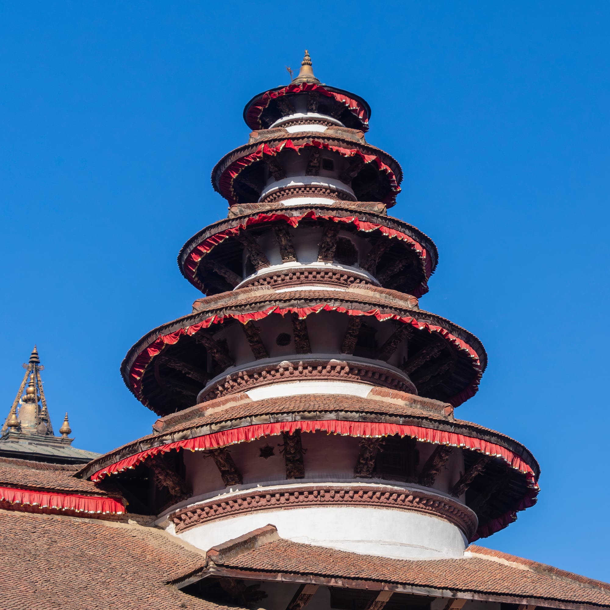 Ornately carved wooden pagoda-style temples clustered in an old palace square