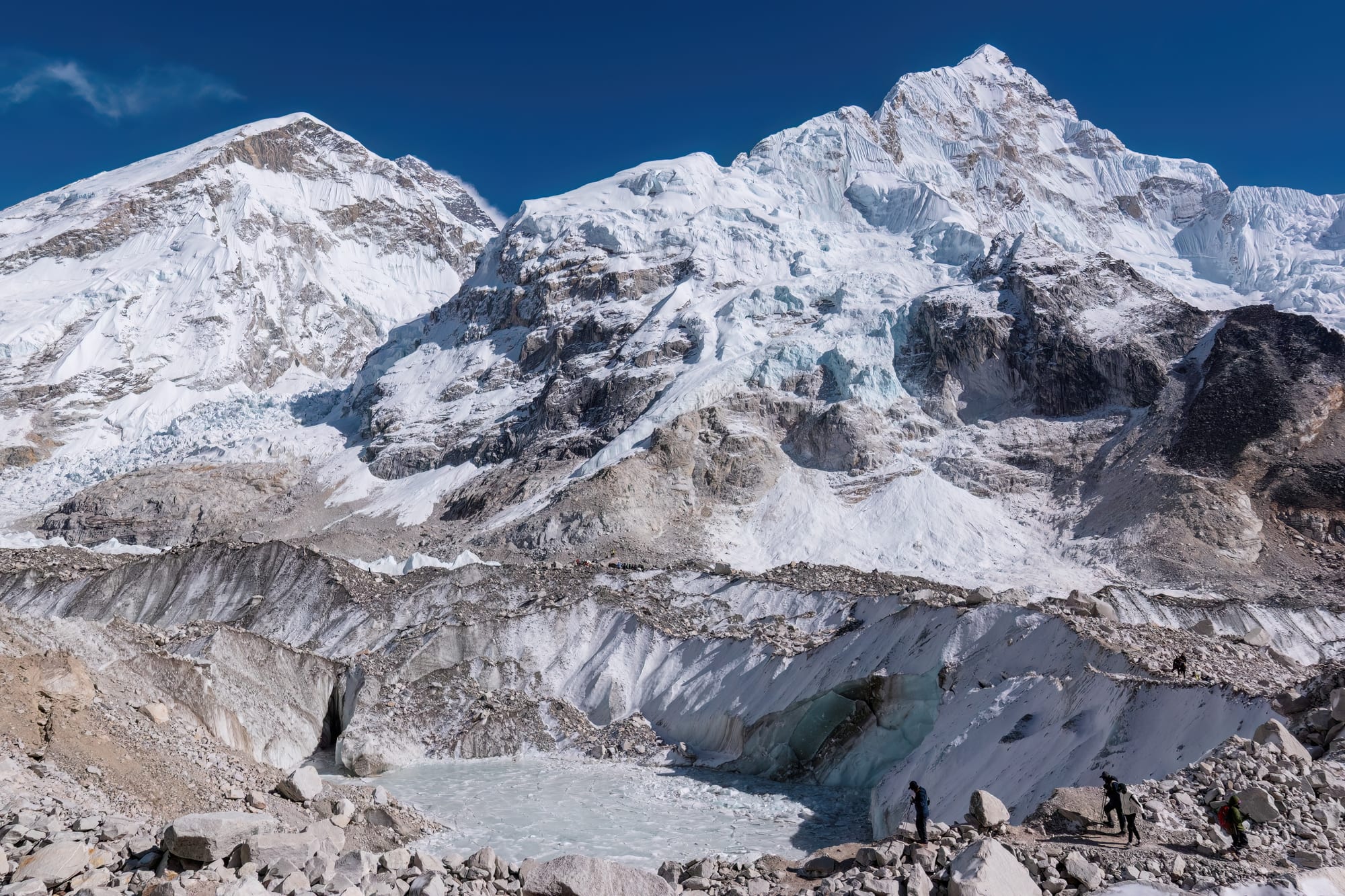 Snow-covered Himalayan peaks rising sharply above a rocky glacial valley