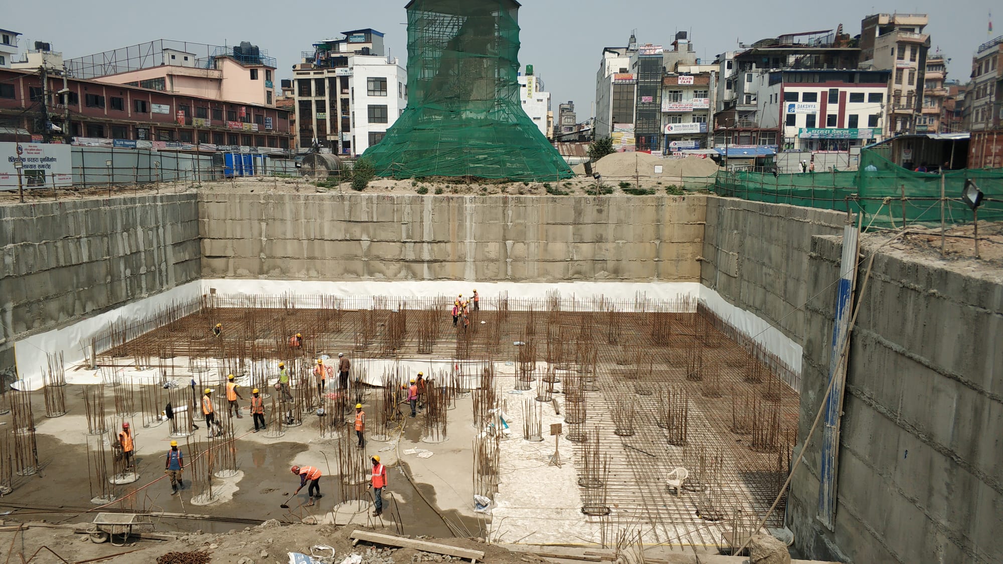 Cranes and scaffolding around the rebuilding of the tall white Dharahara tower in Kathmandu
