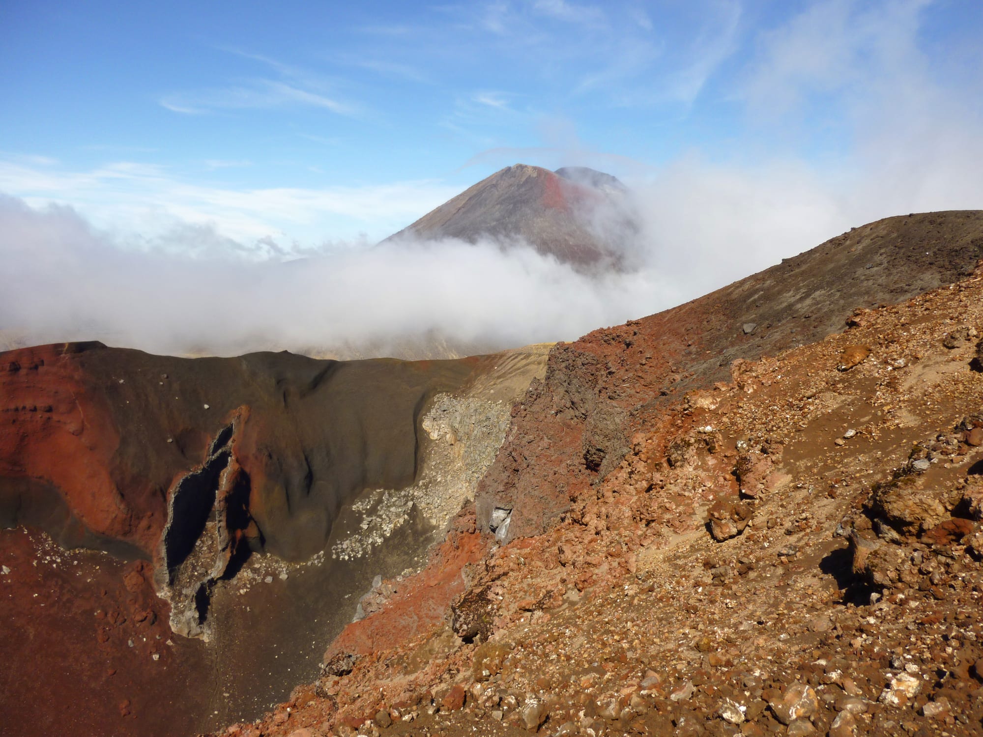 A volcanic crater landscape with a perfect conical peak in the background