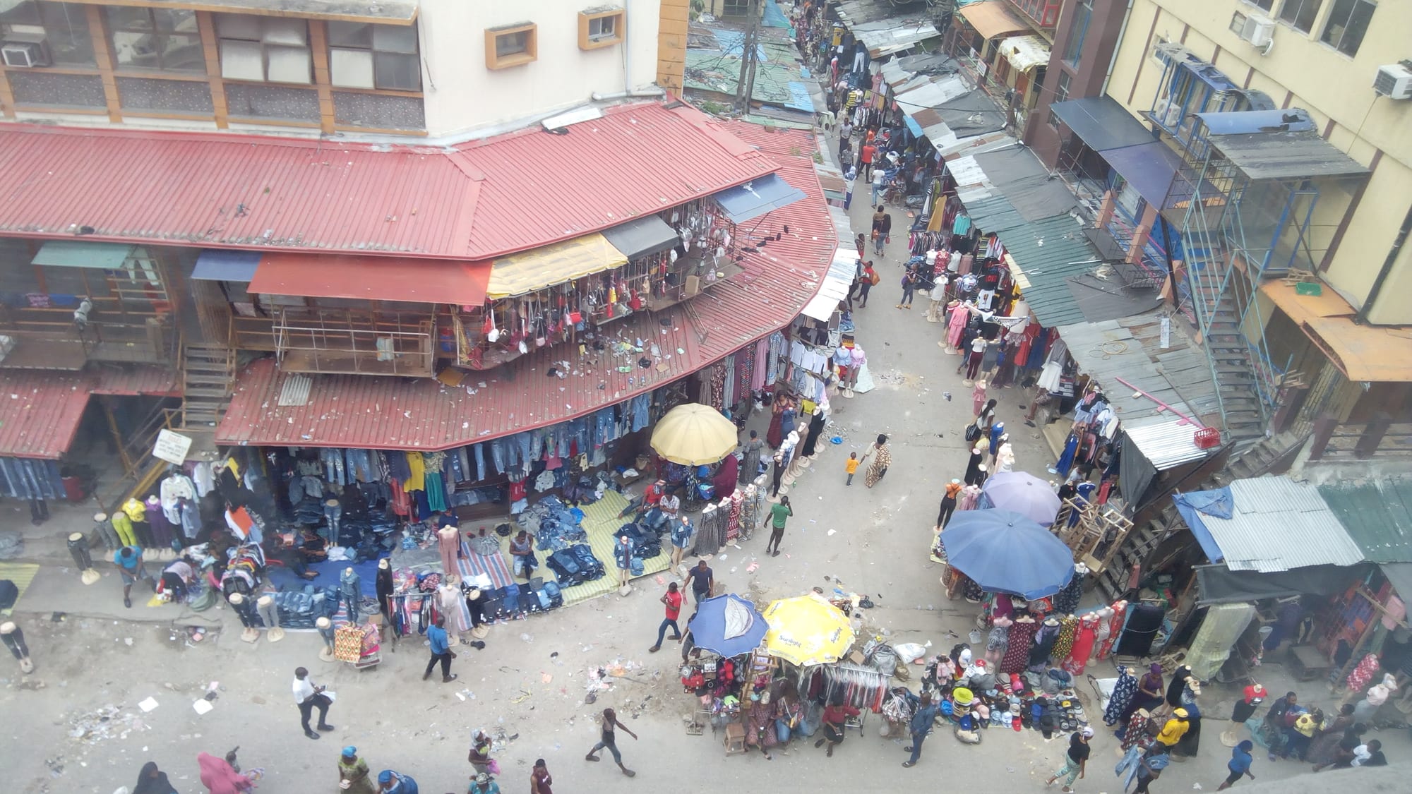 An overhead view of the densely packed stalls, awnings and crowded lanes of Balogun Market on Lagos Island