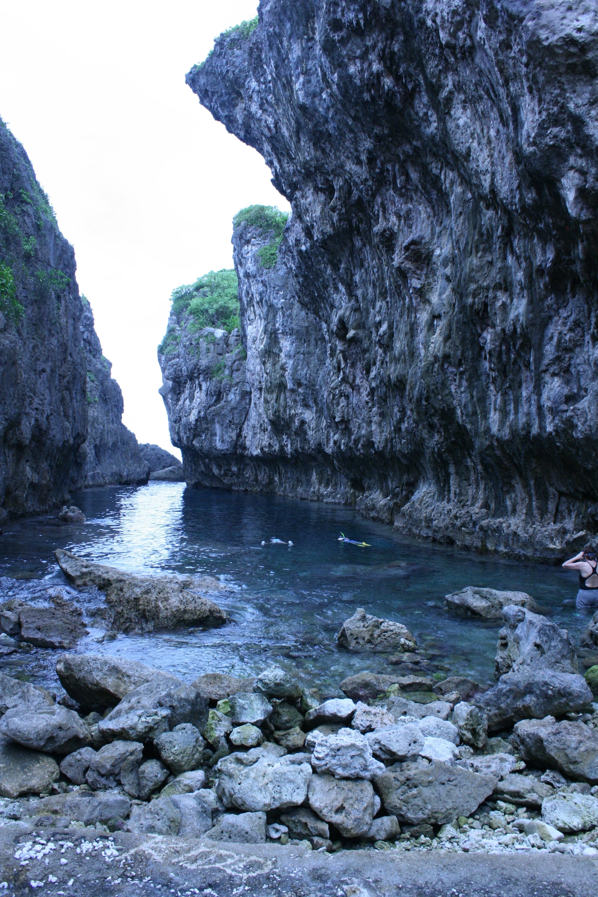 A narrow limestone chasm filled with still, exceptionally clear turquoise water