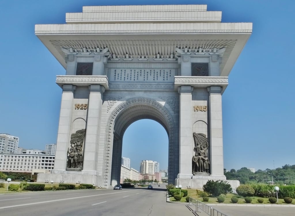 A large stone triumphal arch, taller than the one in Paris, on a Pyongyang street