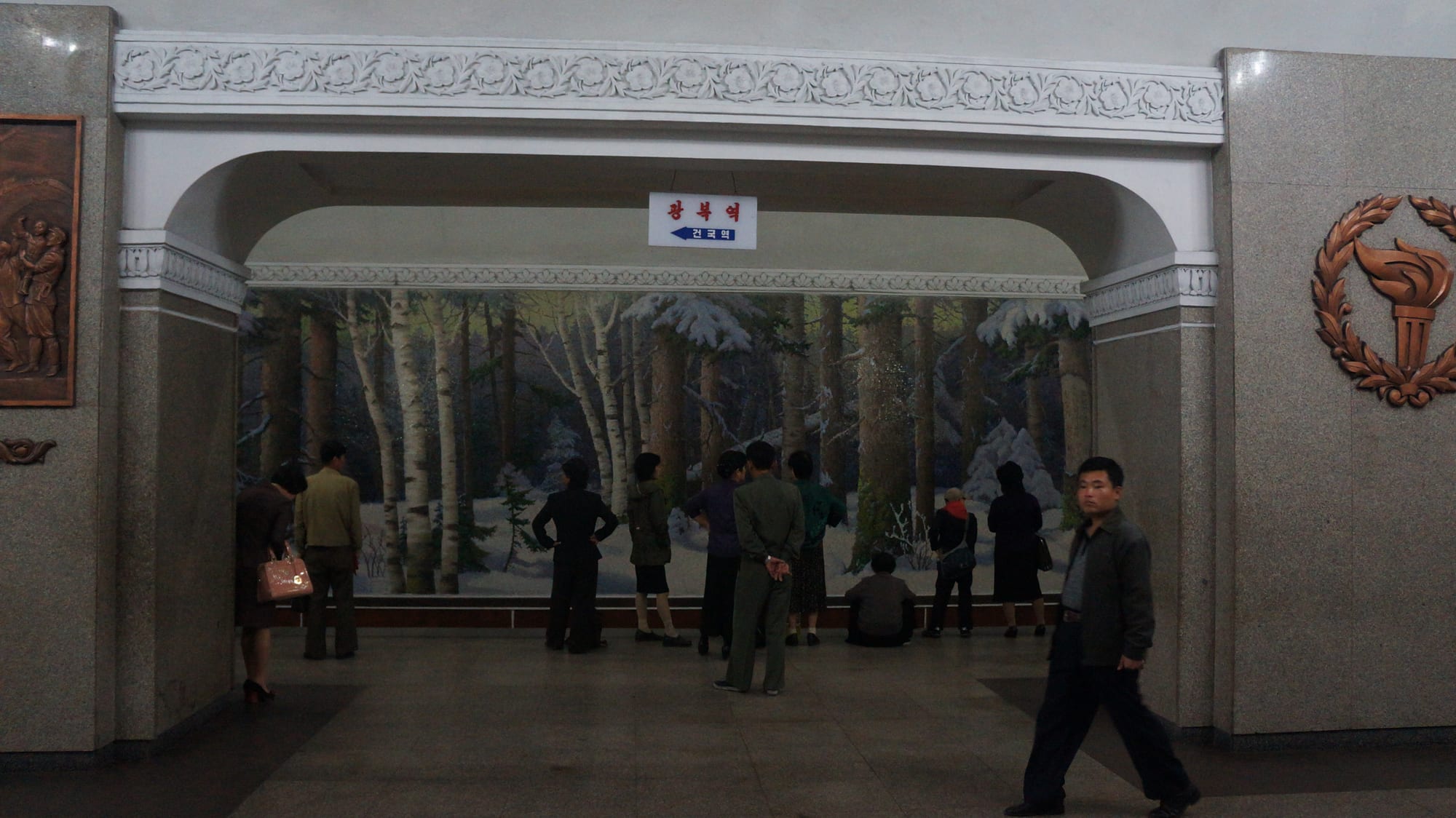 An ornate underground metro station with chandeliers and murals, built deep underground