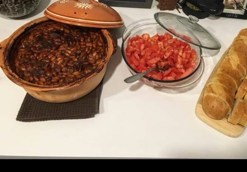 A dish of baked beans in a reddish sauce