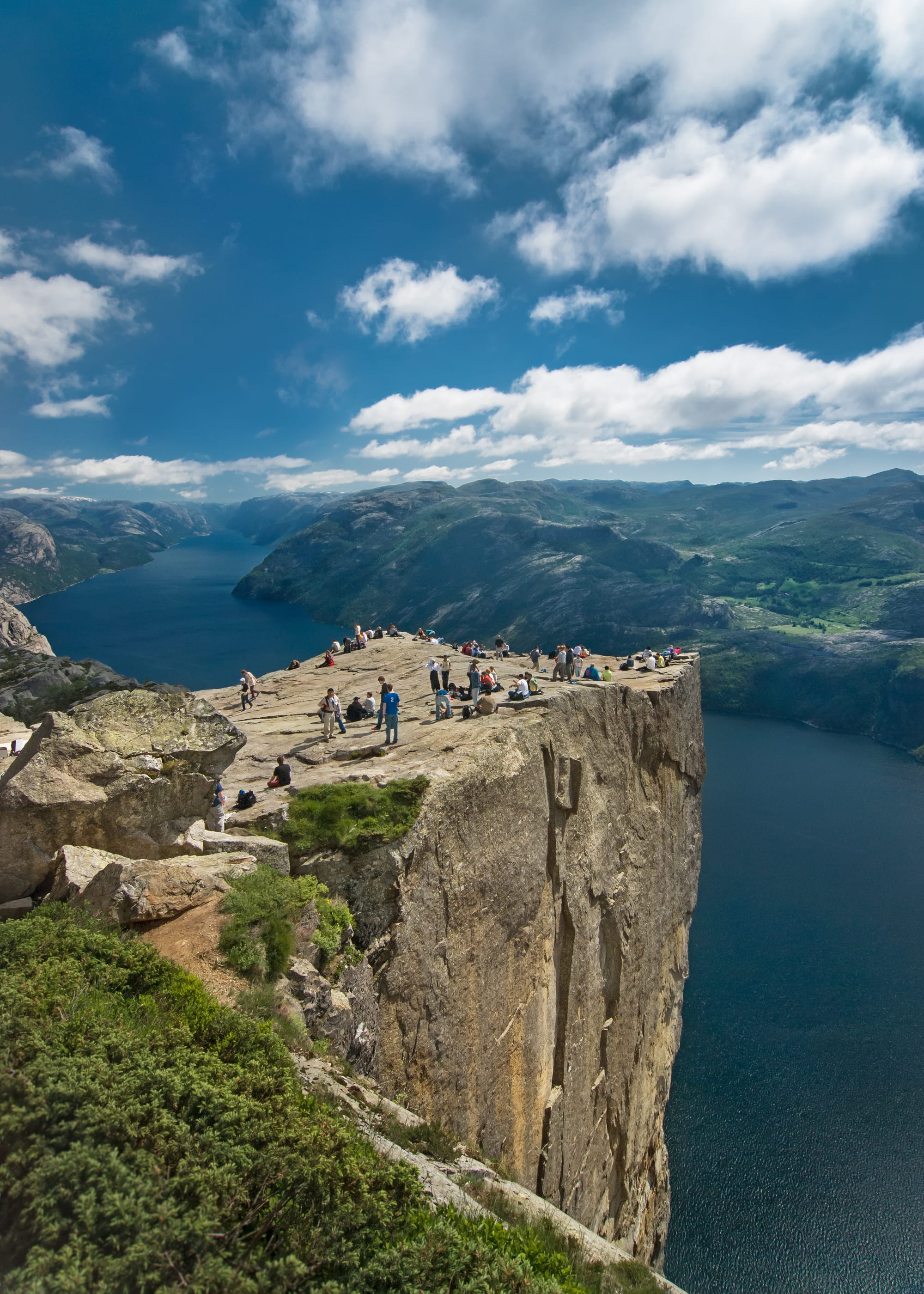 A flat rectangular rock plateau jutting out high above a fjord