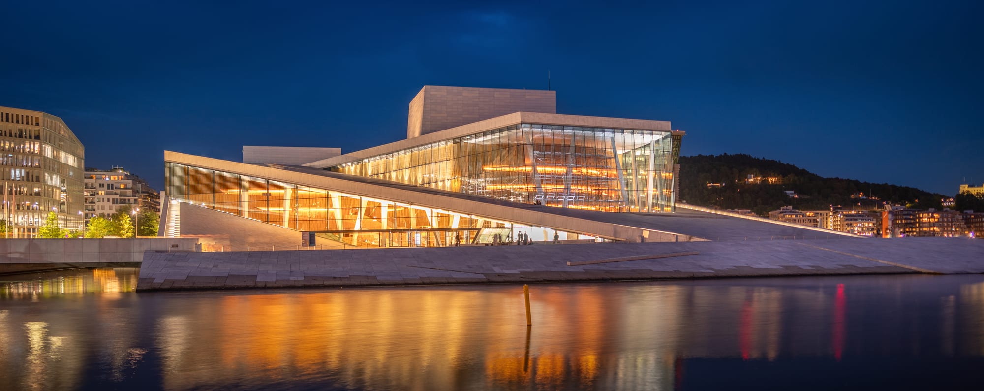 A striking angular white building resembling a glacier rising from the water