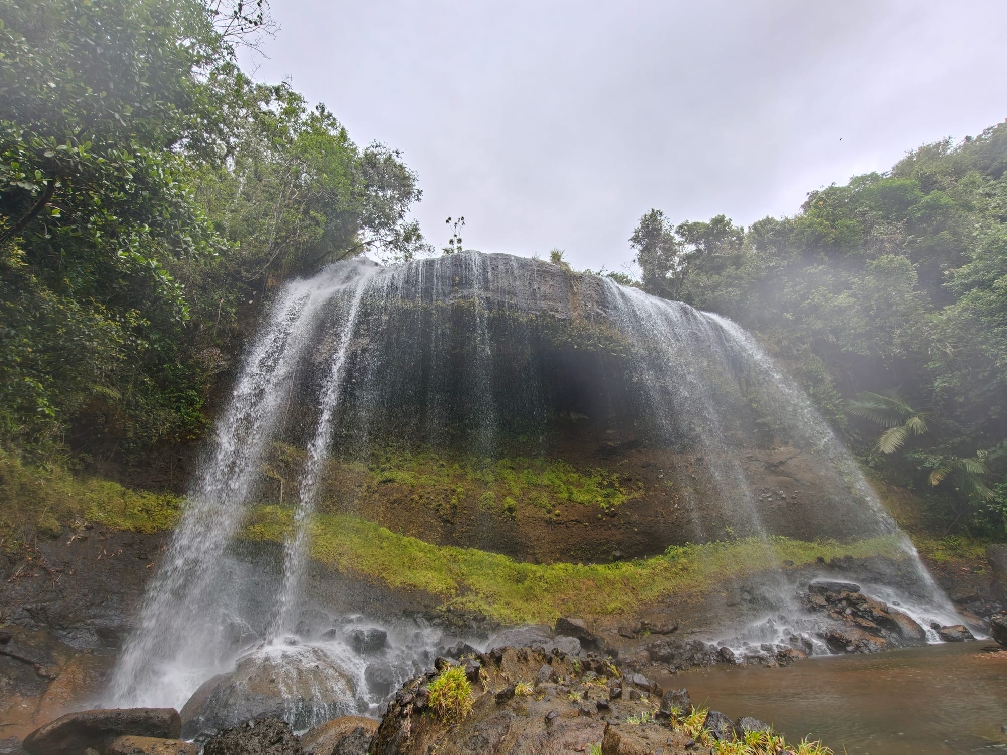 A waterfall cascading through dense green rainforest