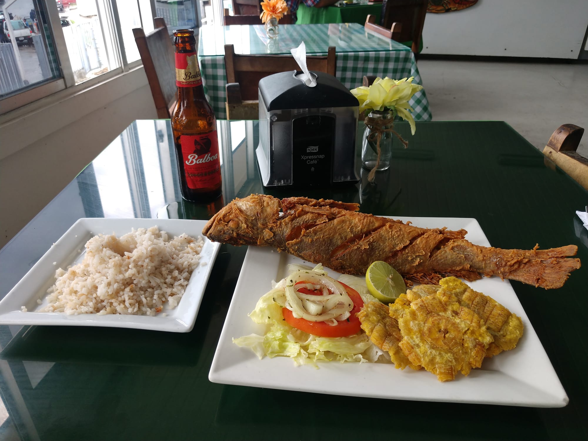 A plate of coconut rice, fried fish and fried plantain
