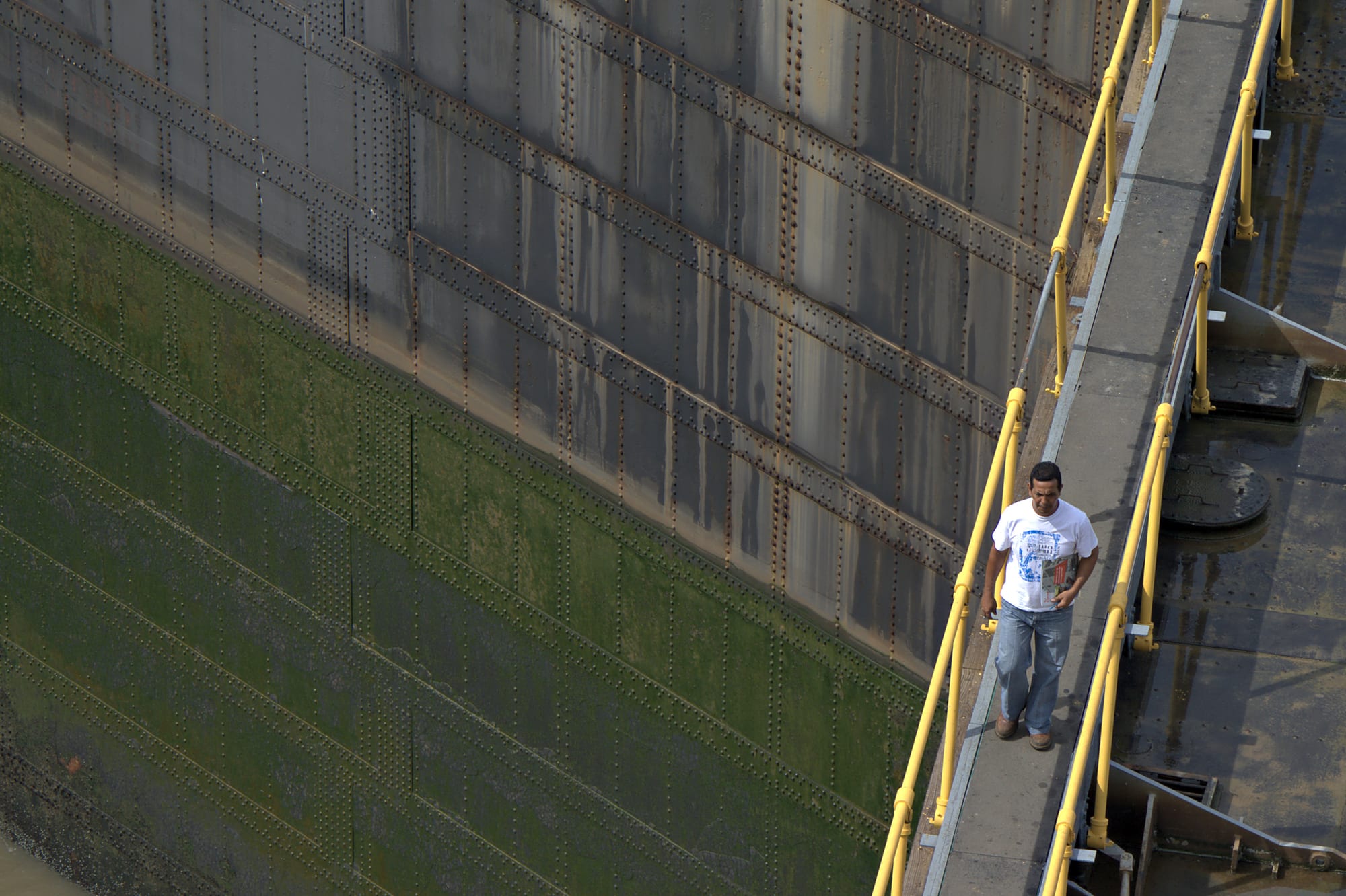 A ship being raised in the Miraflores locks of the Panama Canal, with lock gates and a control building