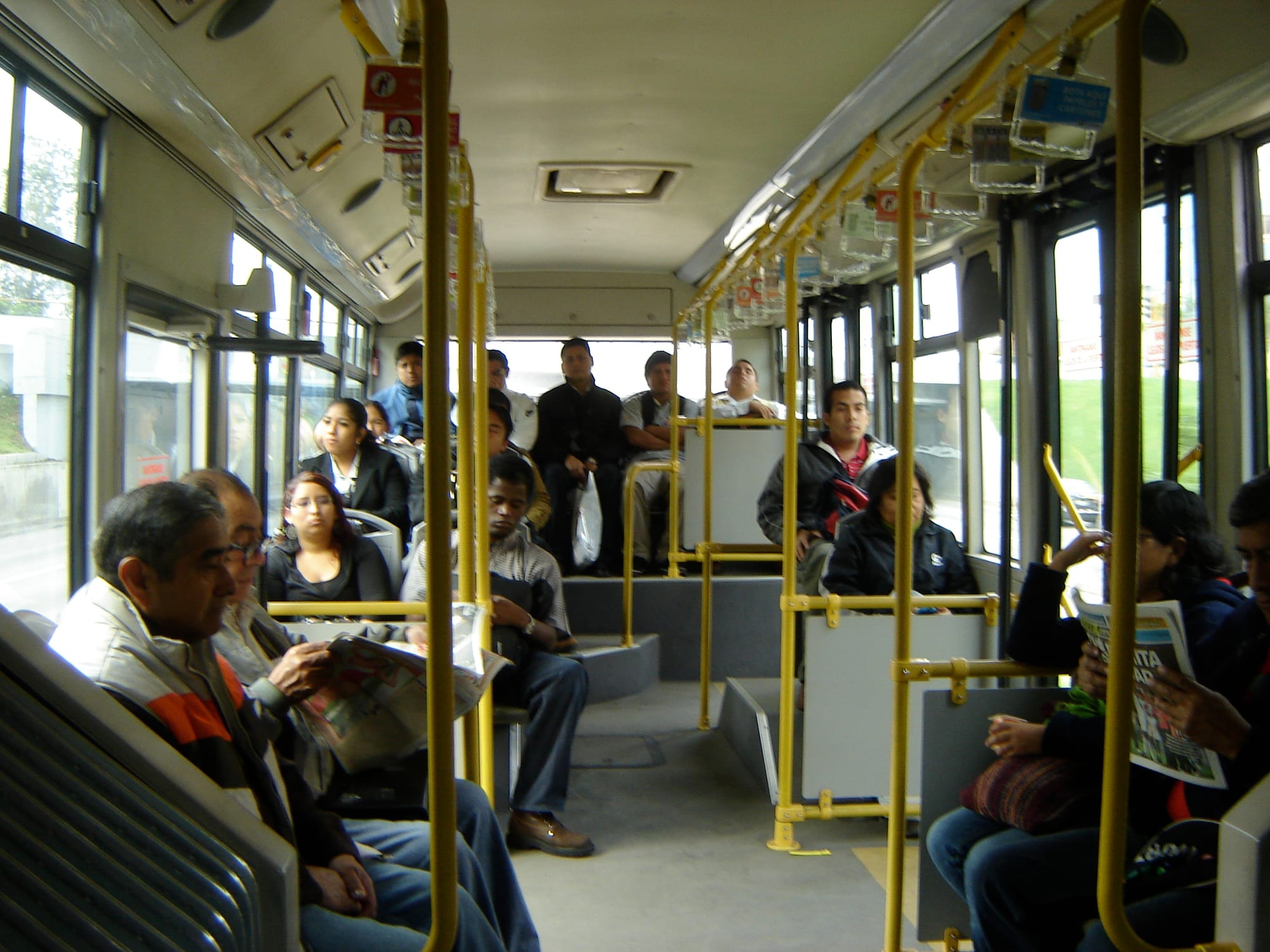 Passengers seated and standing inside a Lima Metropolitano bus rapid transit vehicle