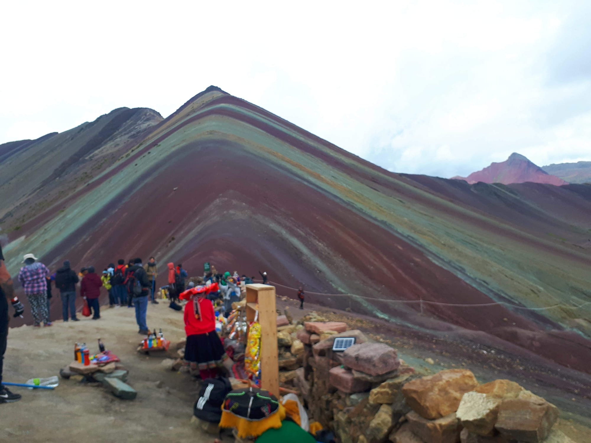 A mountain with distinct stripes of red, gold, and lavender mineral colouring