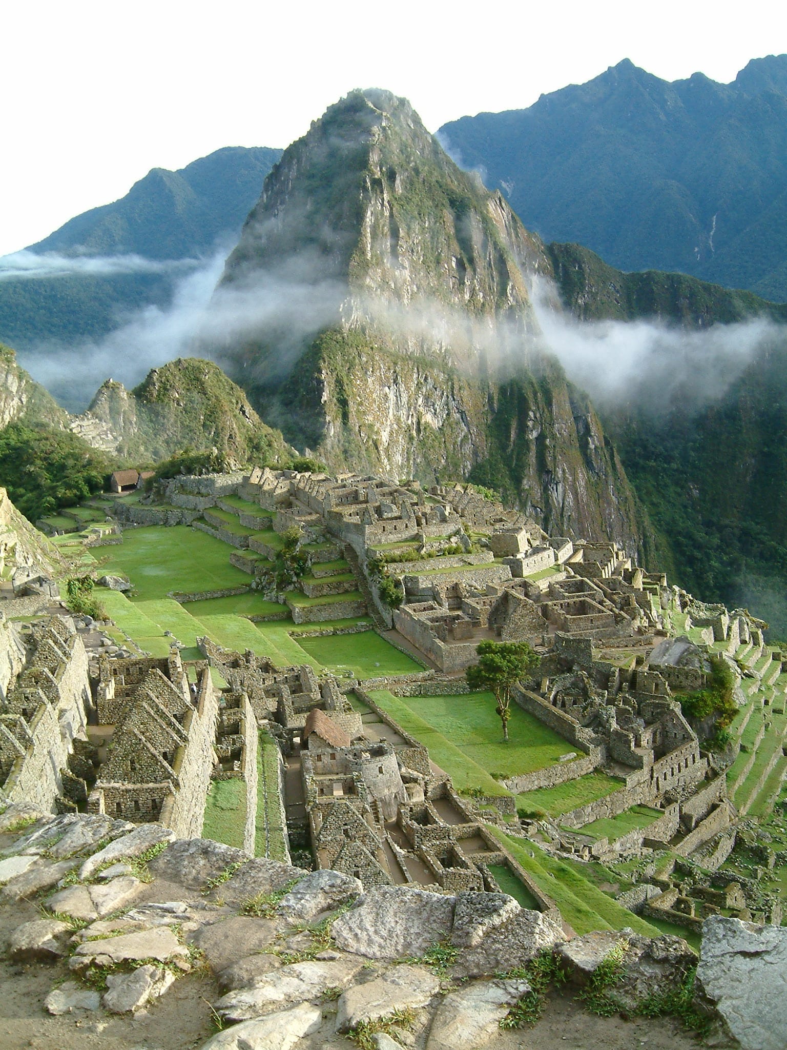 Ancient stone ruins bathed in golden morning light with mountains behind