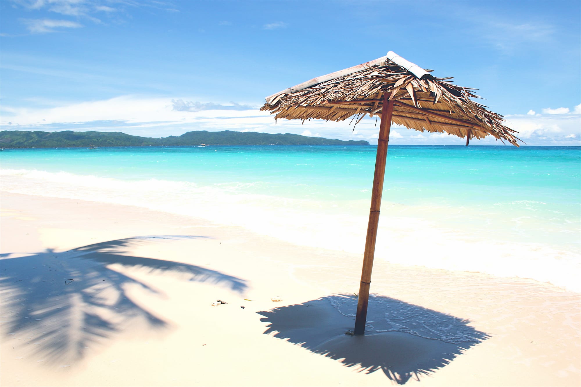 A long stretch of white sand beach with clear turquoise water