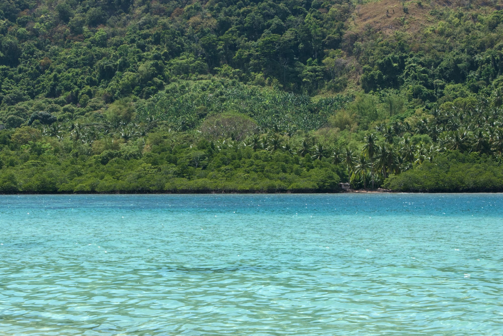 Steep limestone islands rising from turquoise water in a tropical bay