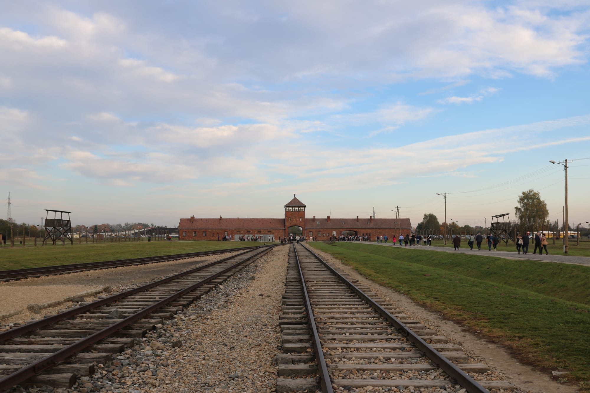 The brick gatehouse of Auschwitz II-Birkenau with railway tracks running through the archway