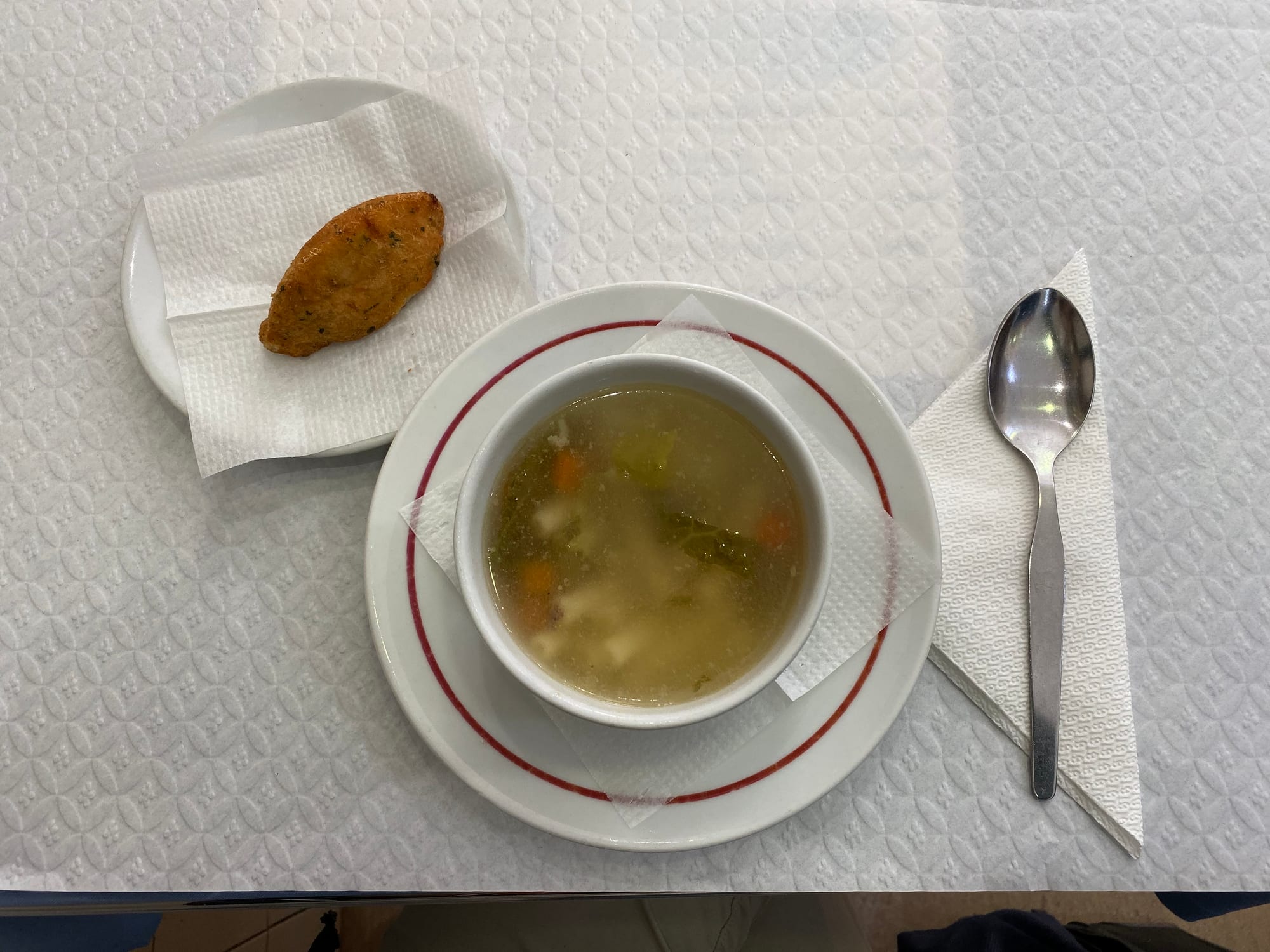A plate of cod with soup on the side
