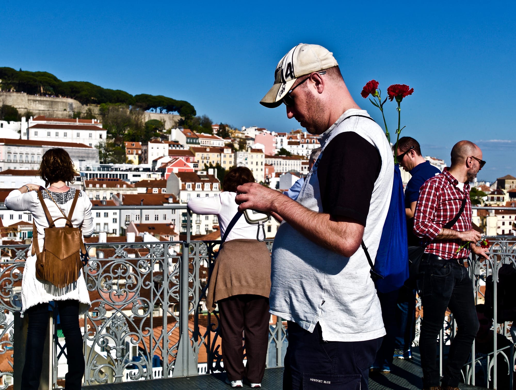 A crowd carrying red carnations and Portuguese flags at a commemoration of the 1974 revolution in Lisbon