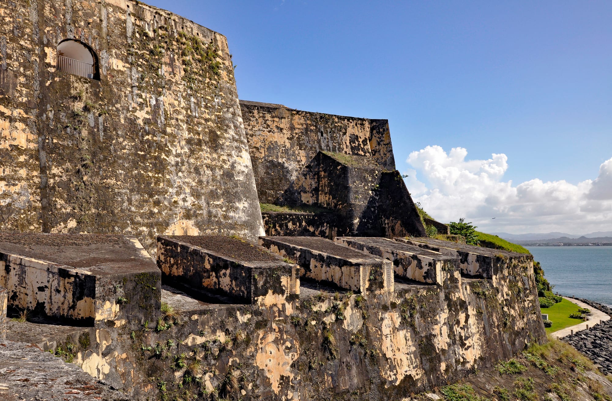 Massive stone fortress walls and battlements overlooking the ocean