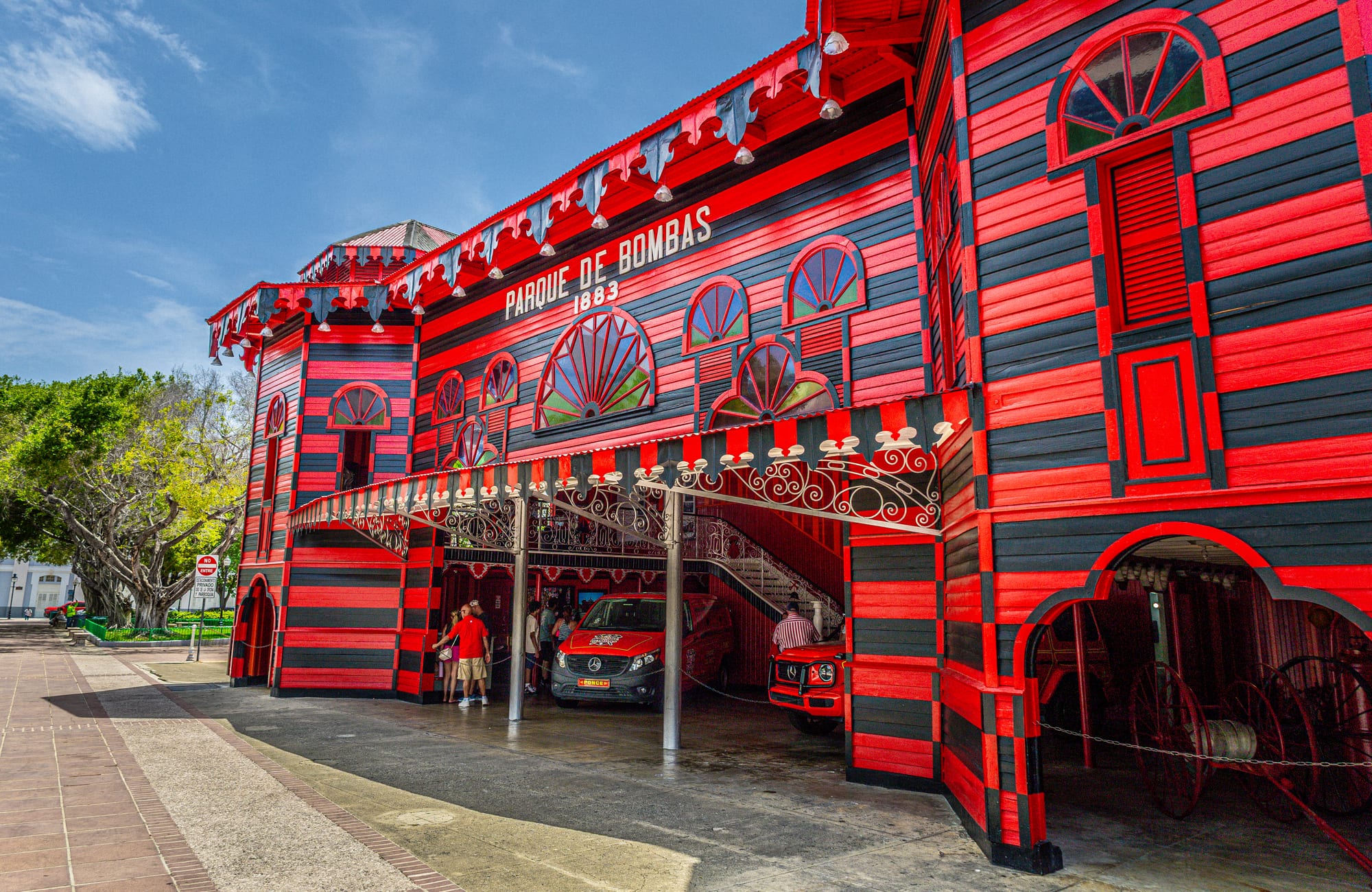 A striking red-and-black striped Victorian firehouse building
