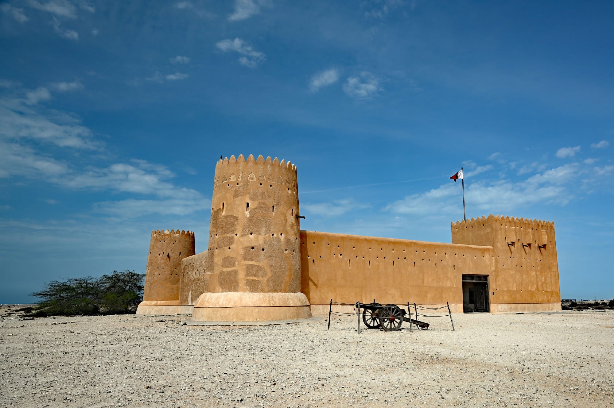 A square desert fort with corner towers standing in an arid landscape